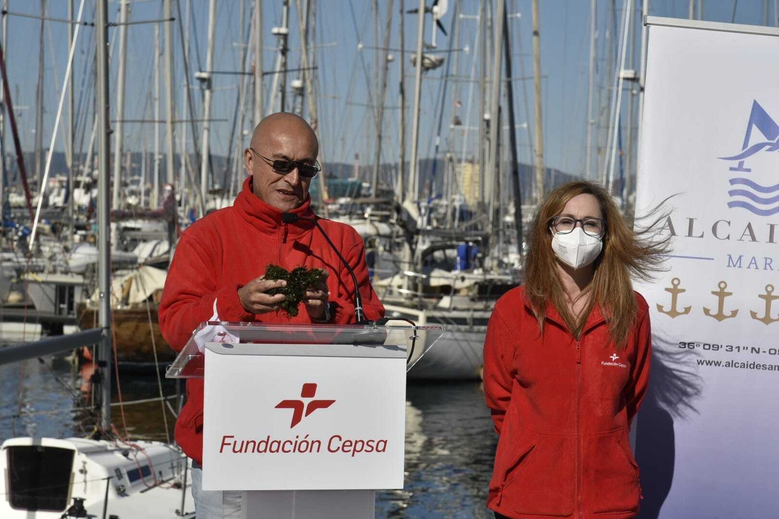 José Carlos García Gómez, con algas en las manos, junto a Estrella Blanco, de la Fundación Cepsa, en Alcaidesa marina.