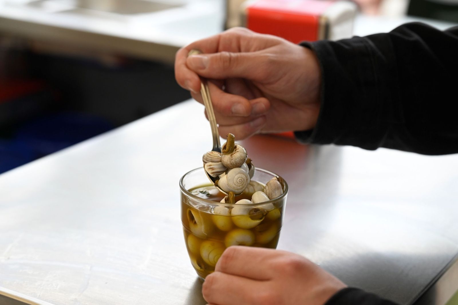 Una persona come caracoles en un puesto de Córdoba.