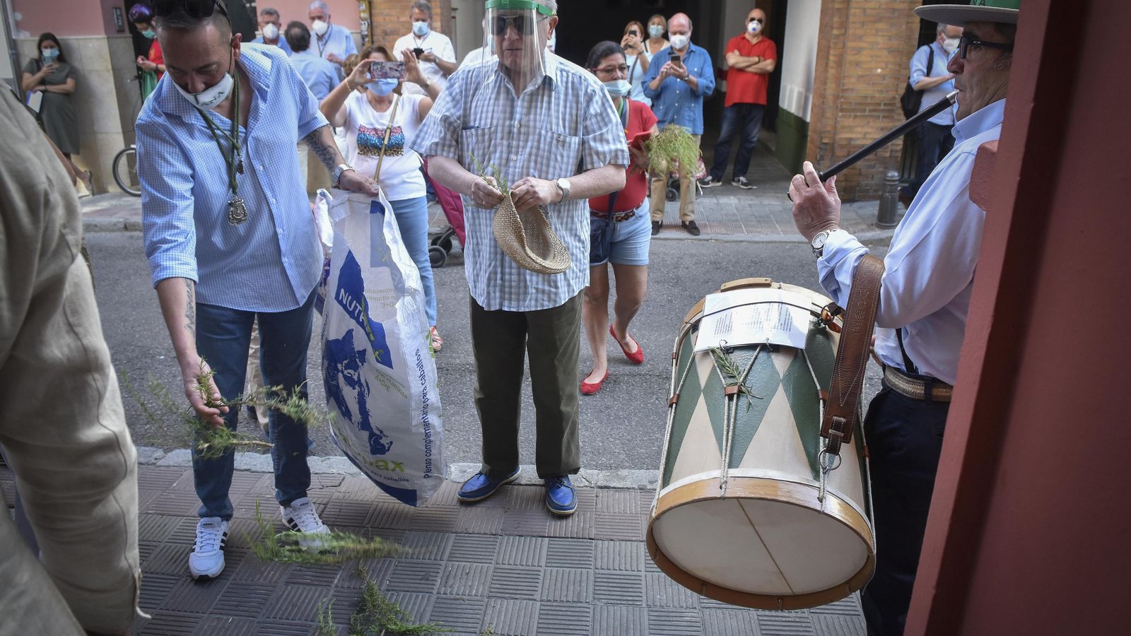 Al son del tamboril se abren las puertas de la capilla de la Virgen del Rocío en Triana, con romero en la entrada.