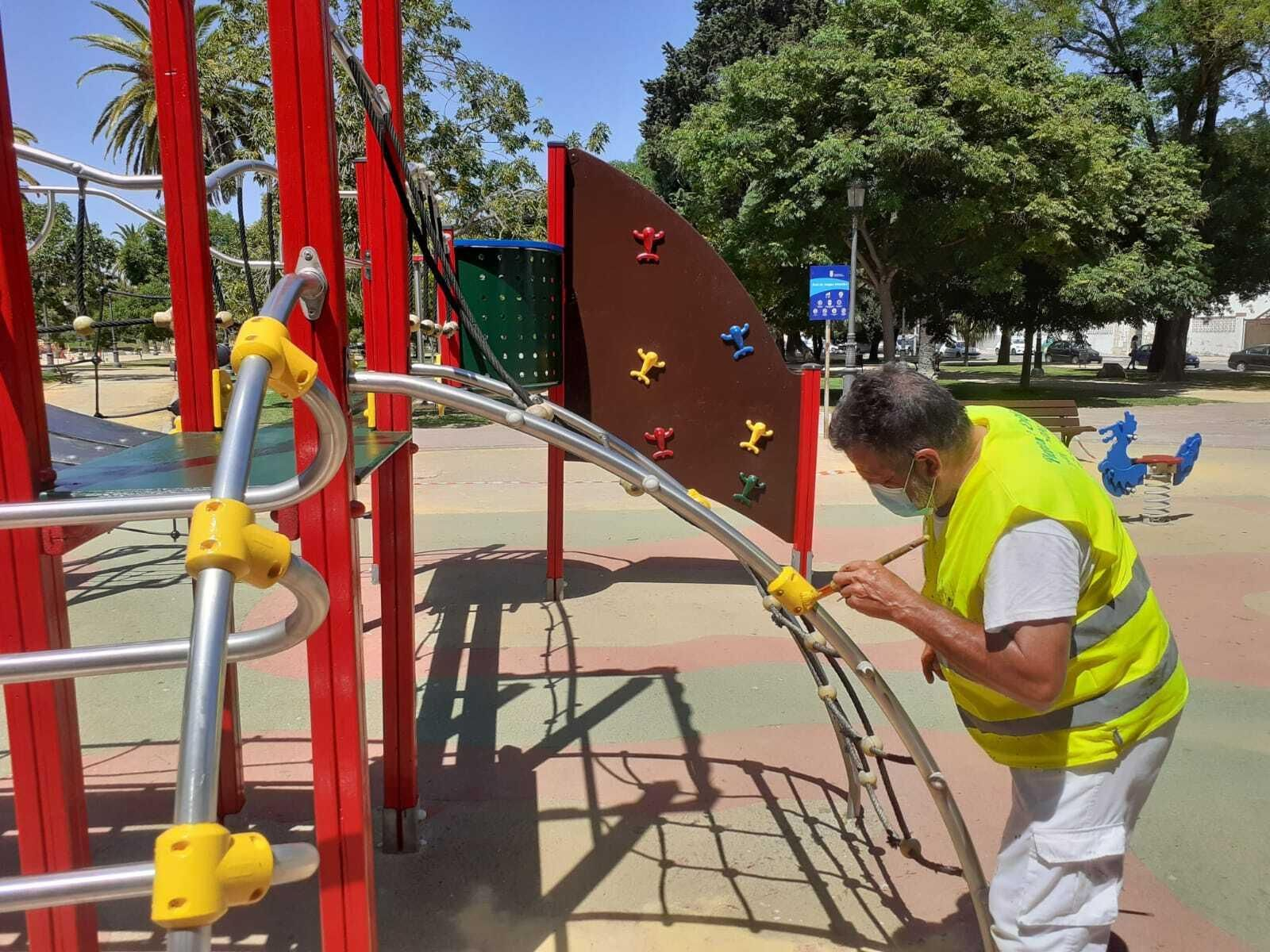 Un empleado de Infraestructuras pintando el parque.