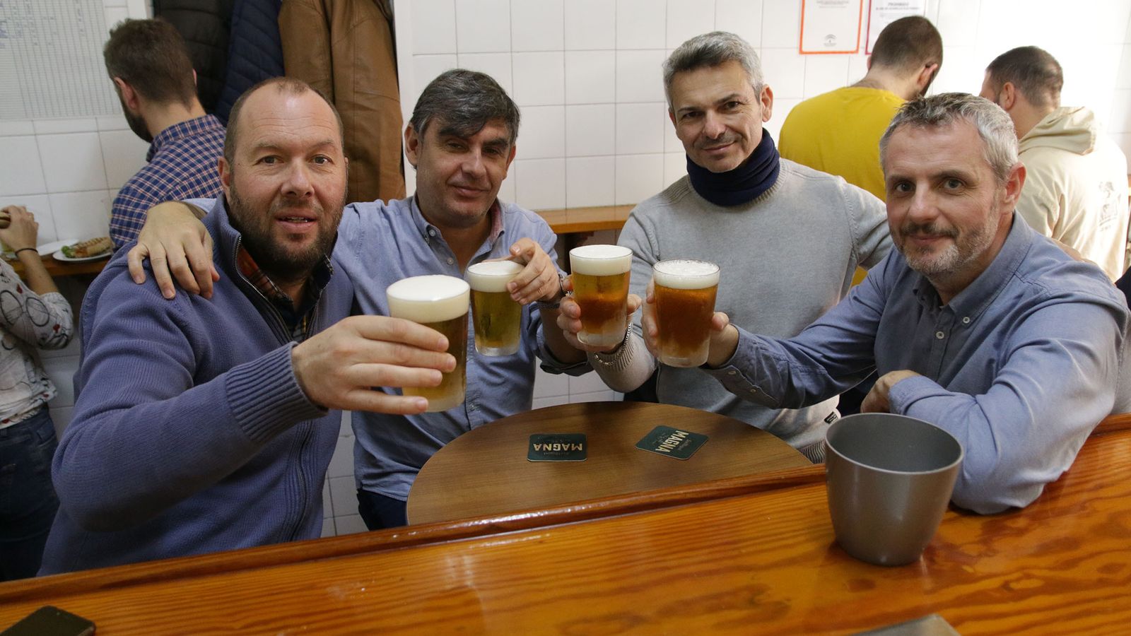 Clientes de El Morata celebran su cita en la añeja barra con cerveza.