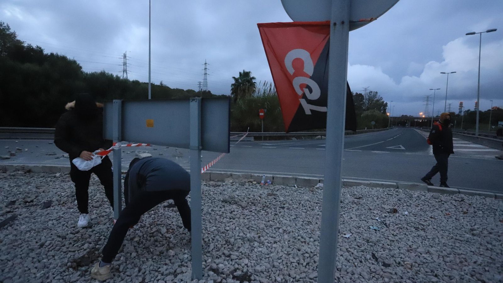 Dos integrantes del piquete cogen  piedras de la glorieta de la CA-34.