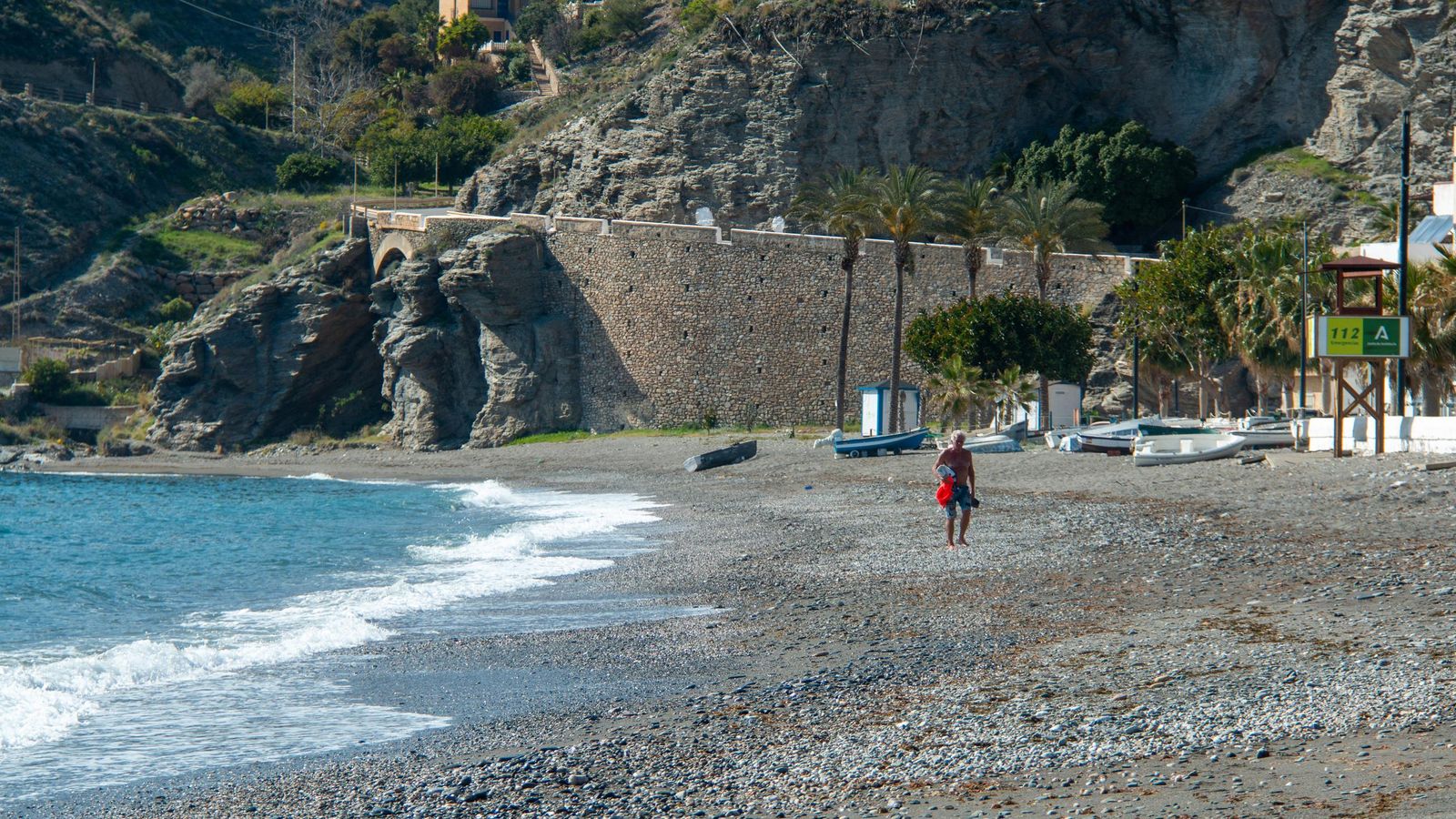Una persona camina por la playa de La Rábita