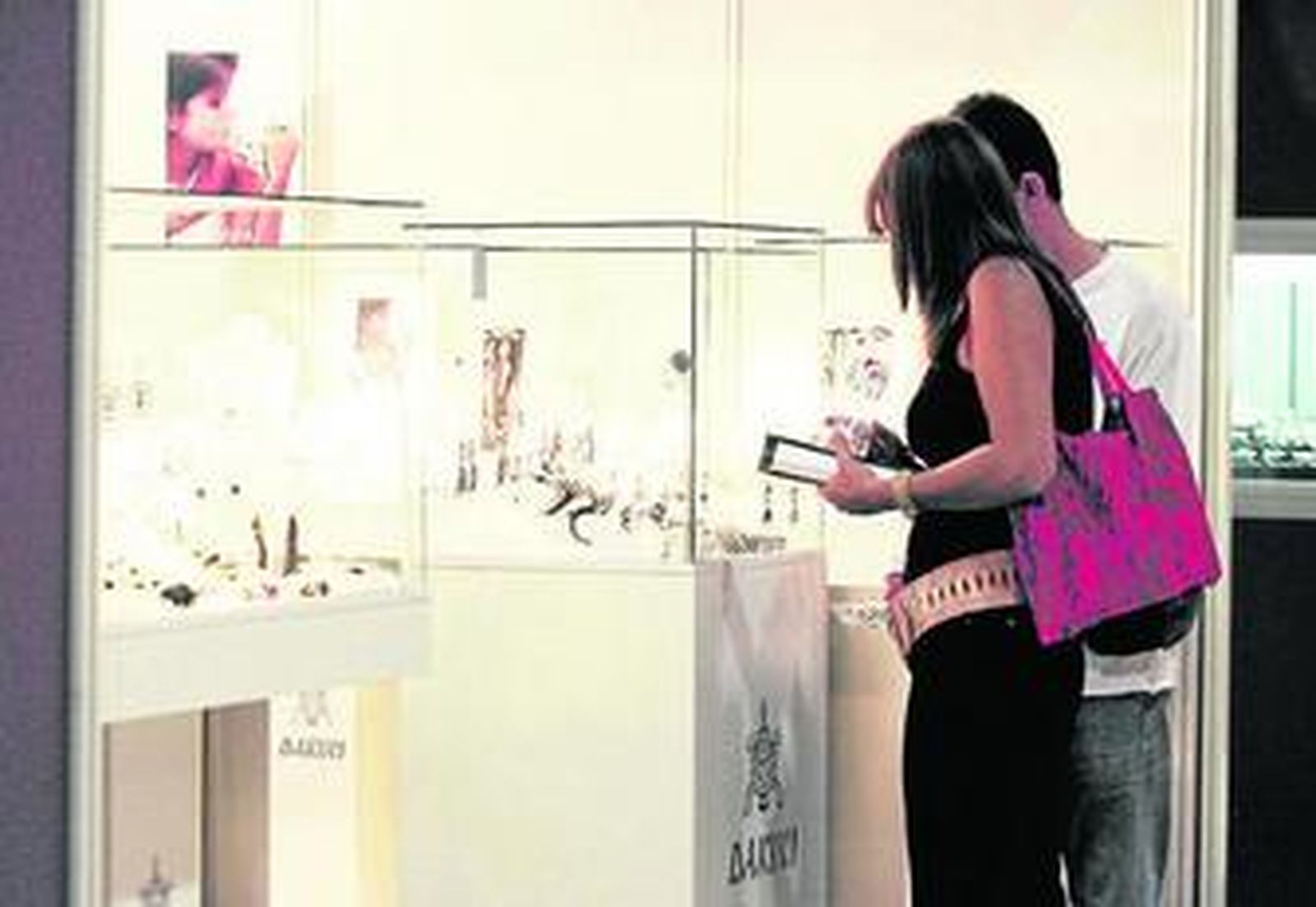 Dos personas observan los expositores de Iberjoya.