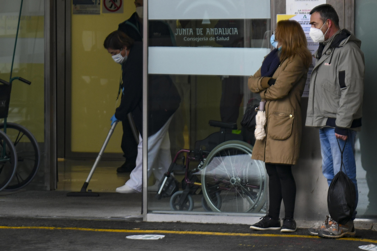 Dos familiares de un paciente aguardan en la puerta de Urgencias de un hospital