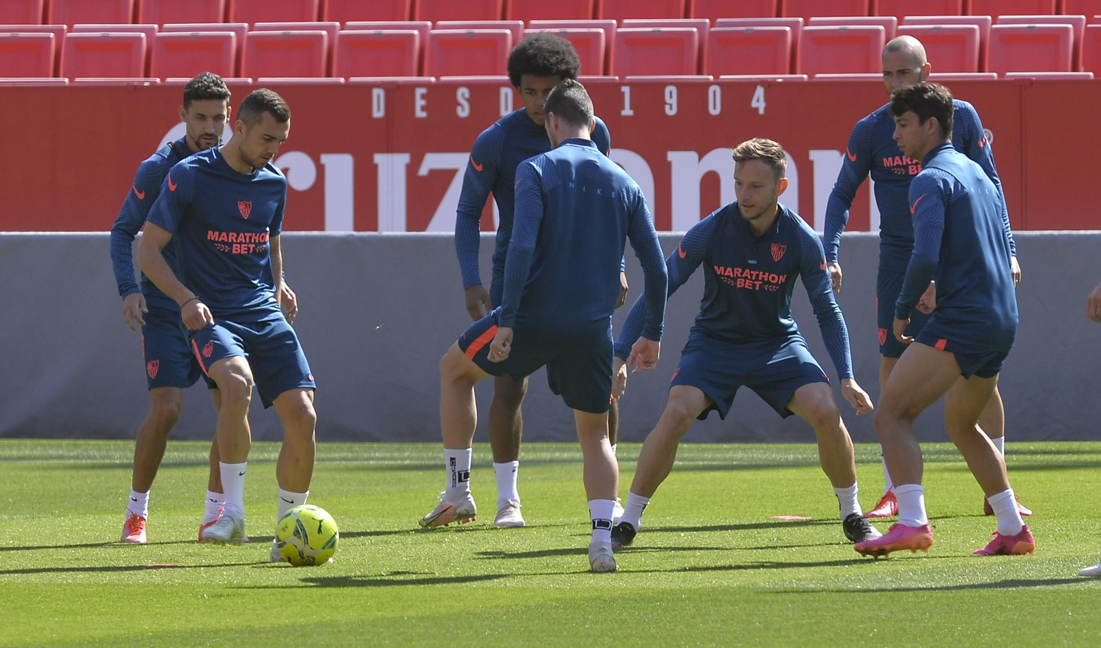 Joan Jordán toca el balón en un rondo en el que participa Koundé.