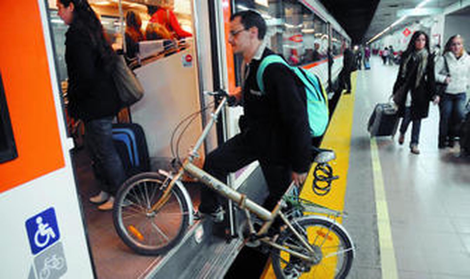 Un ciclista accede a uno de los trenes de Cercanías, en la estación de San Bernardo.