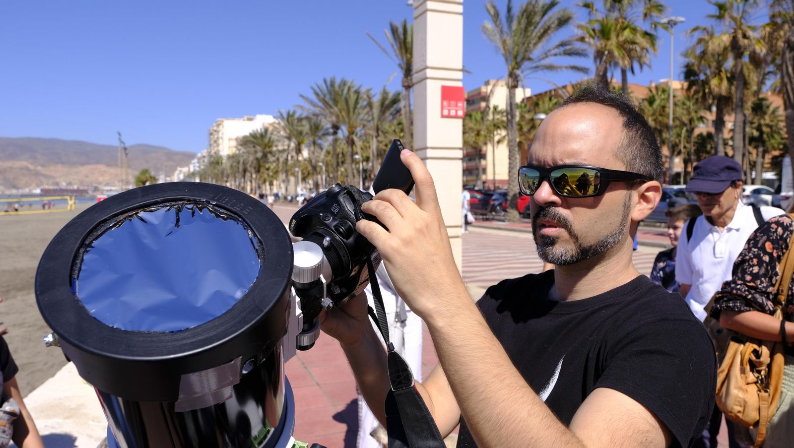 Almería observa el eclipse solar desde el Paseo Marítimo, en imágenes