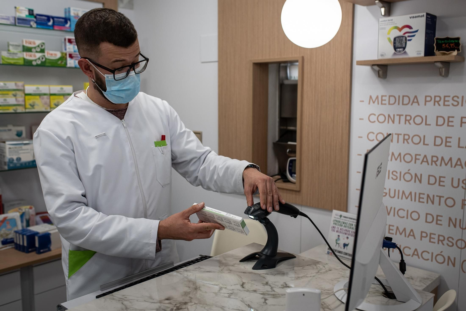 Un farmacéutico procediendo a la venta de un test de antígenos