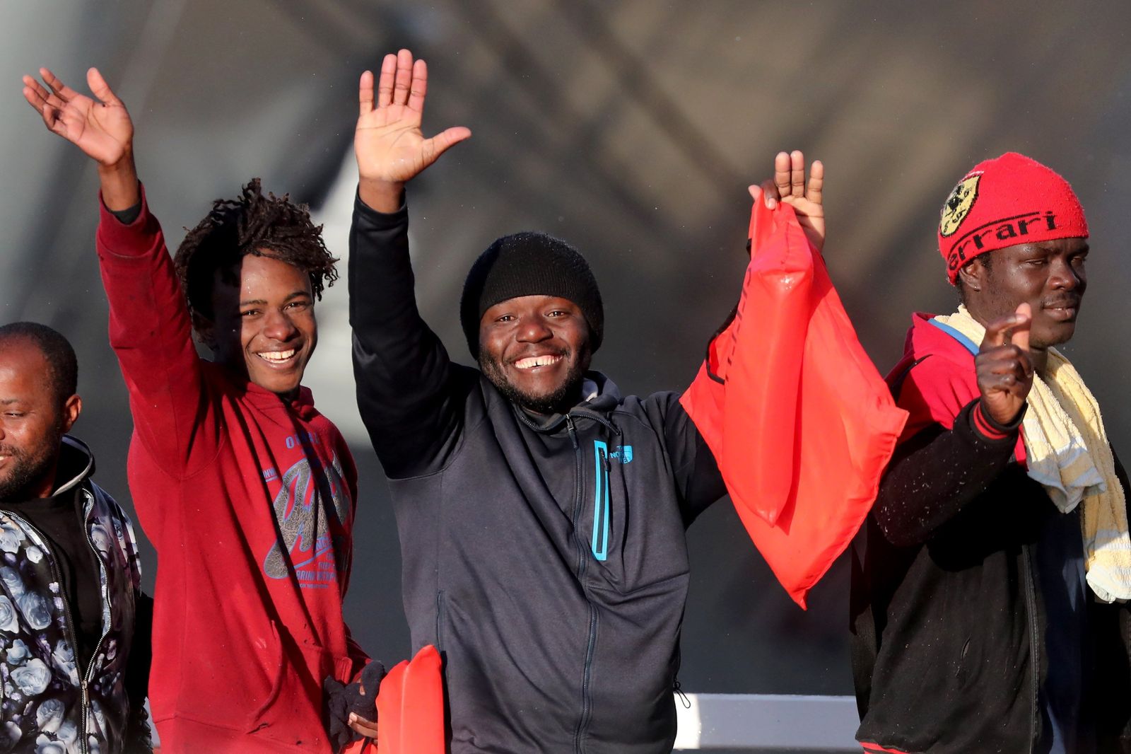 Los inmigrantes saludan a su llegada al puerto naval de Hay Wharf, en Floriana (Malta).