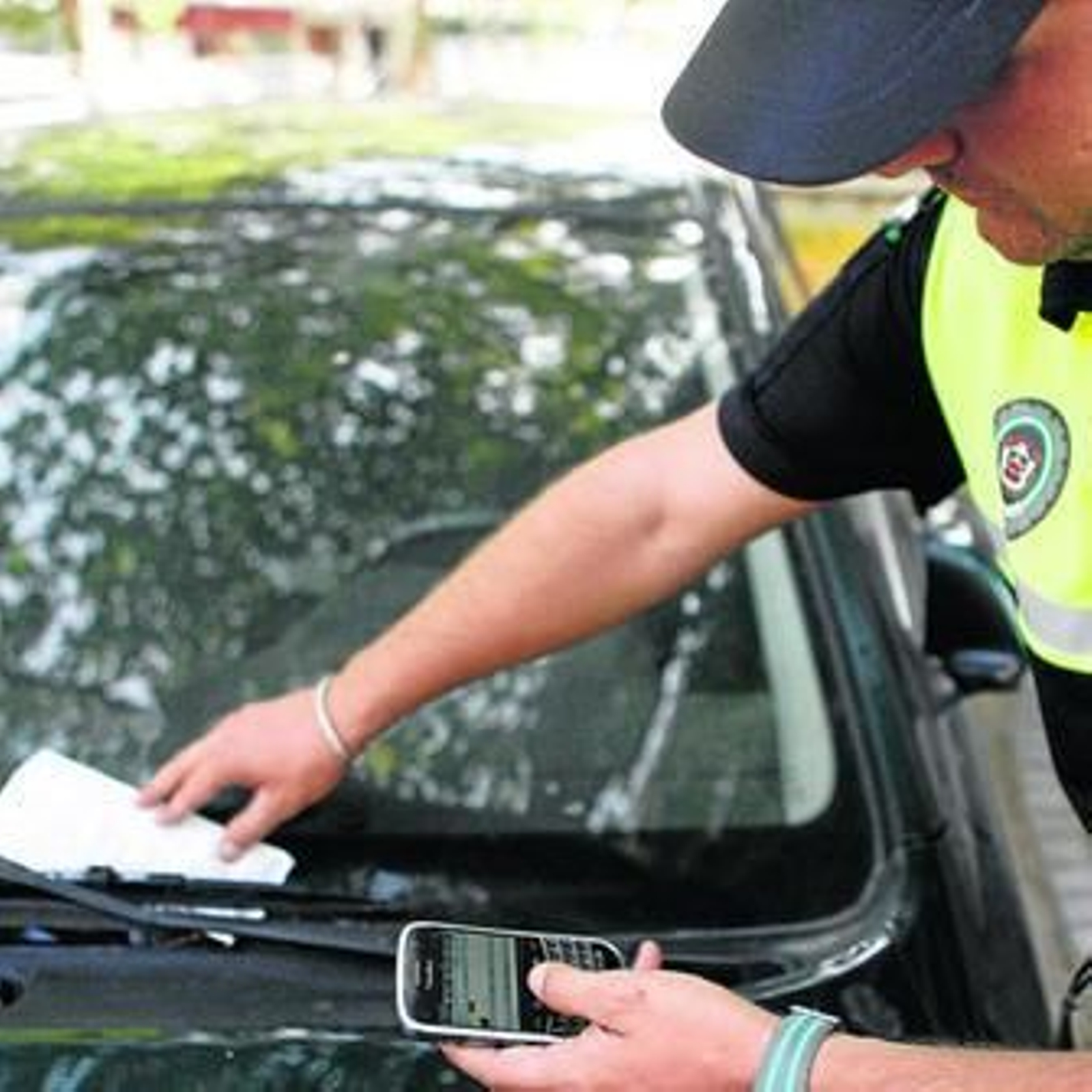Un agente pone una multa con el nuevo sistema controlado por teléfono móvil.