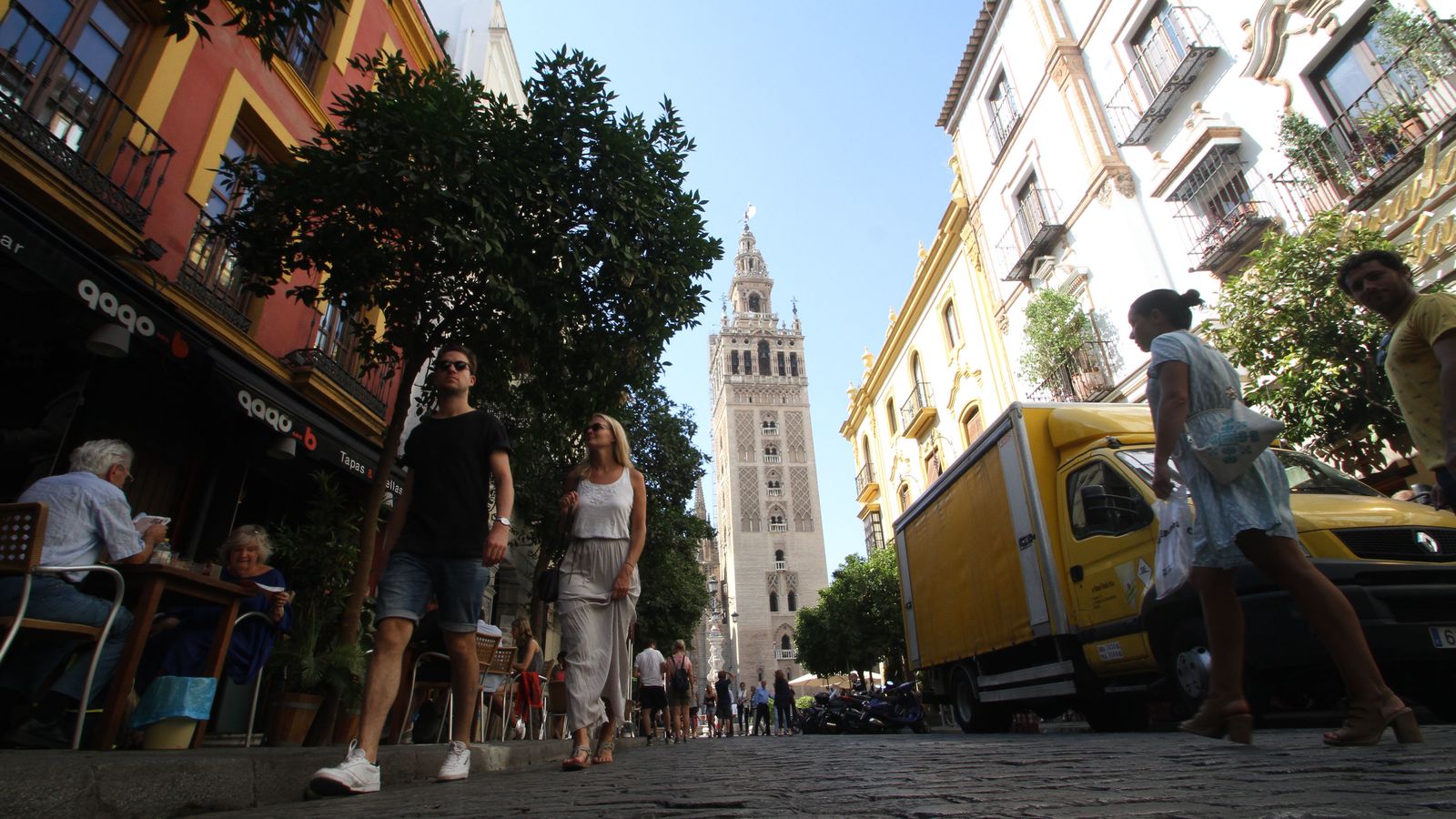 La abundancia de veladores obliga a los peatones a andar por la calzada, en la que se suceden vehículos aparcados de considerable tamaño.