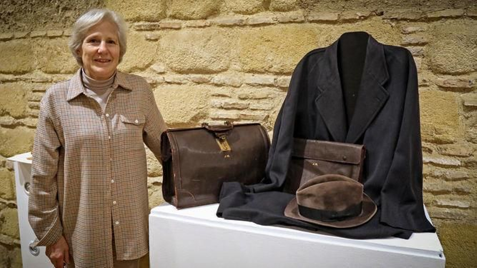 Carmen Negrín junto a la maleta, el gabán y el sombrero de su abuelo, que se exponen en la sala El Molino de El Alcázar de Jerez