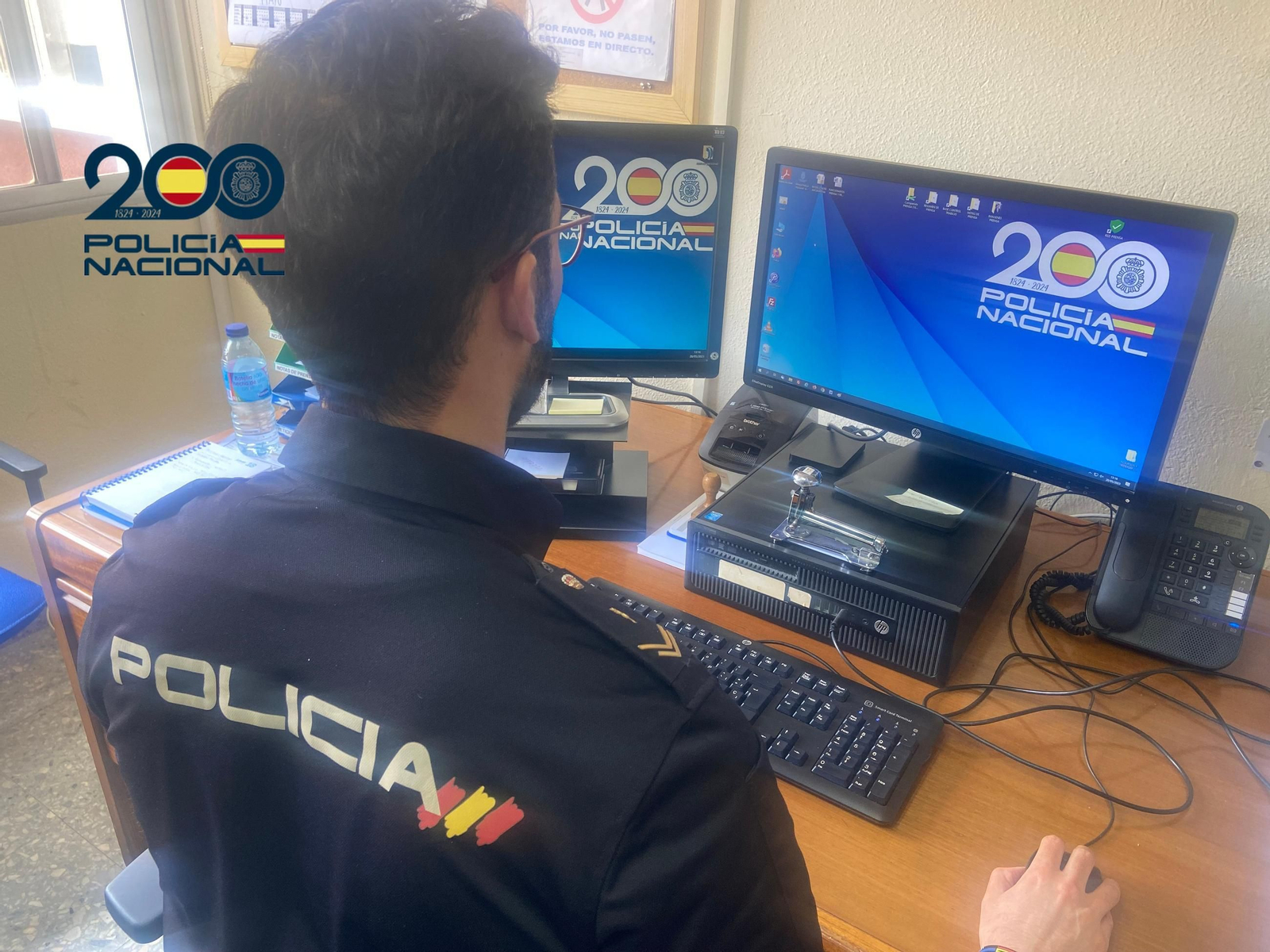 Una agente consulta datos en un ordenador.