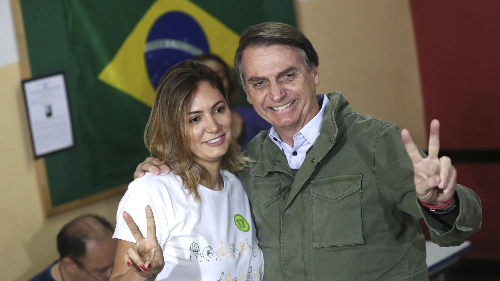 Jair Bolsonaro saluda a los medios después de votar junto a su esposa en Río de Janeiro.