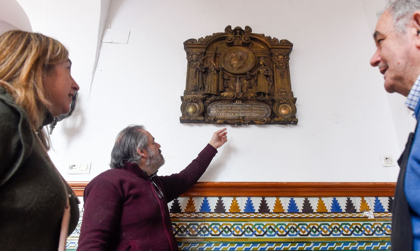 Varias personas observan la placa de gratitud a Antonio de la Peña en el Círculo Mercantil