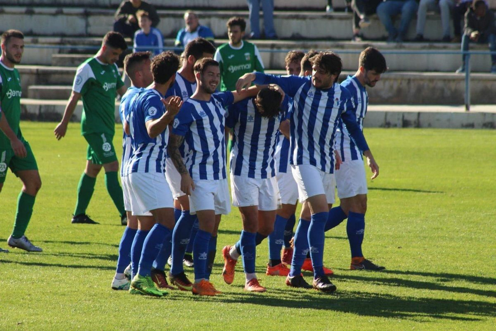 Los jugadores del Écija celebran un gol con los guadalcacileños, ayer de verde, cabizbajos.