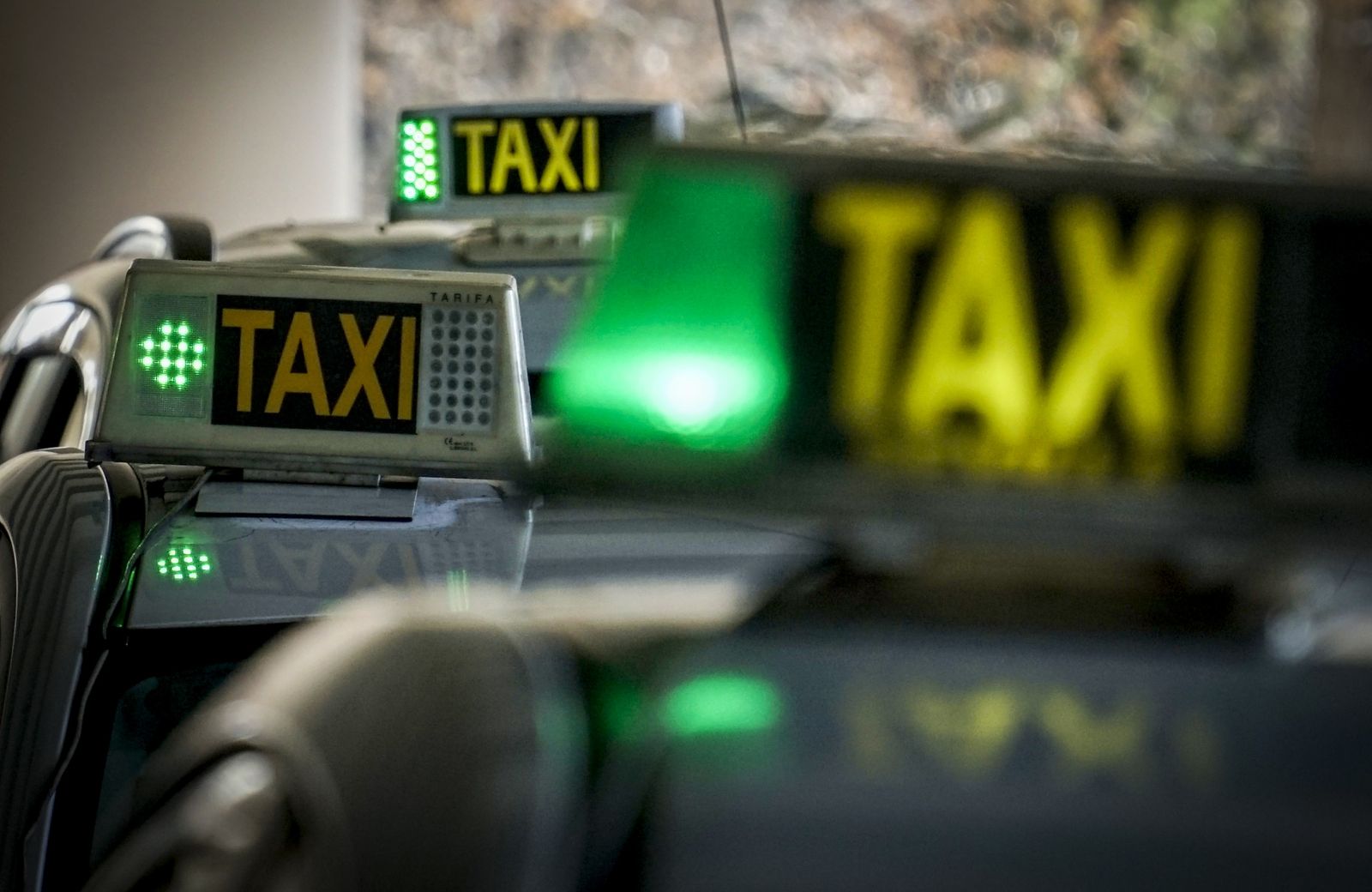 Taxis aparcados con la luz verde que indica que el vehículo está libre para el usuario.