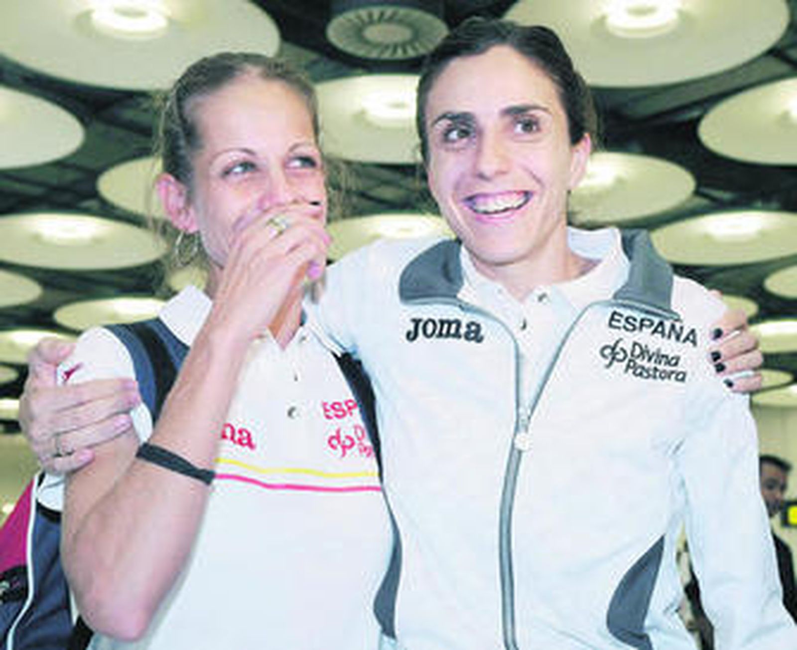 Natalia Rodríguez, se abraza a su compañera Nuria Fernández a su llegada de Berlín.