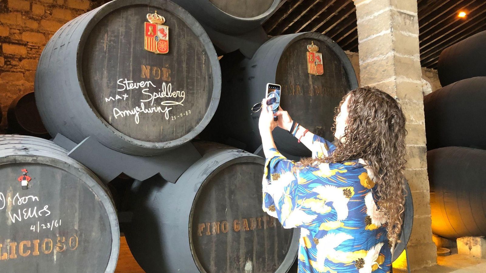 Una visitante fotografía los toneles firmados durante una visita guiada.