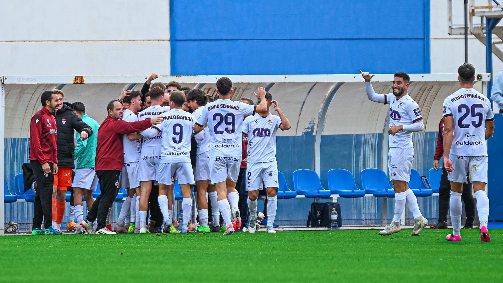 Celebración grupal del tanto de Javi Moyano con el banquillo blanco.