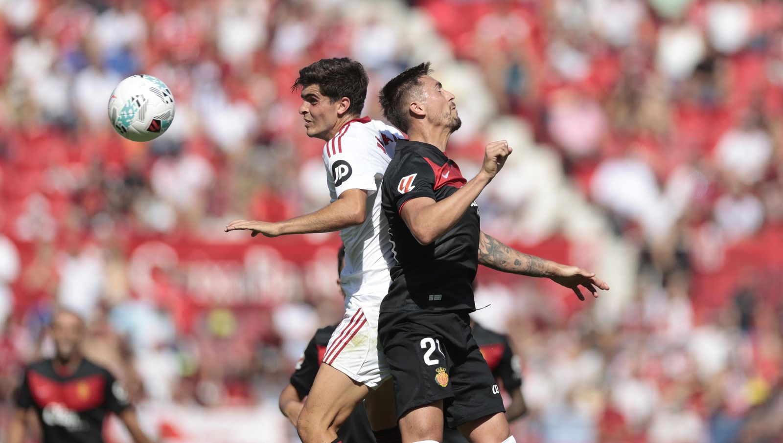 Juanlu pelea un balón por arriba con Raíllo.
