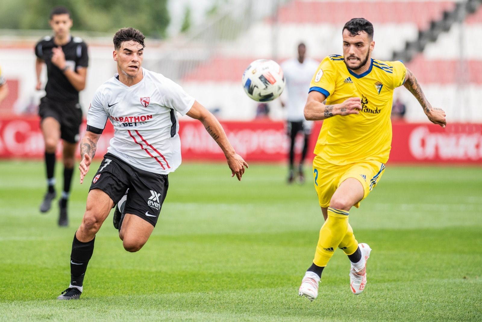 El cadista Álex Martín (d) pugna en carrera con el sevillista Isaac.