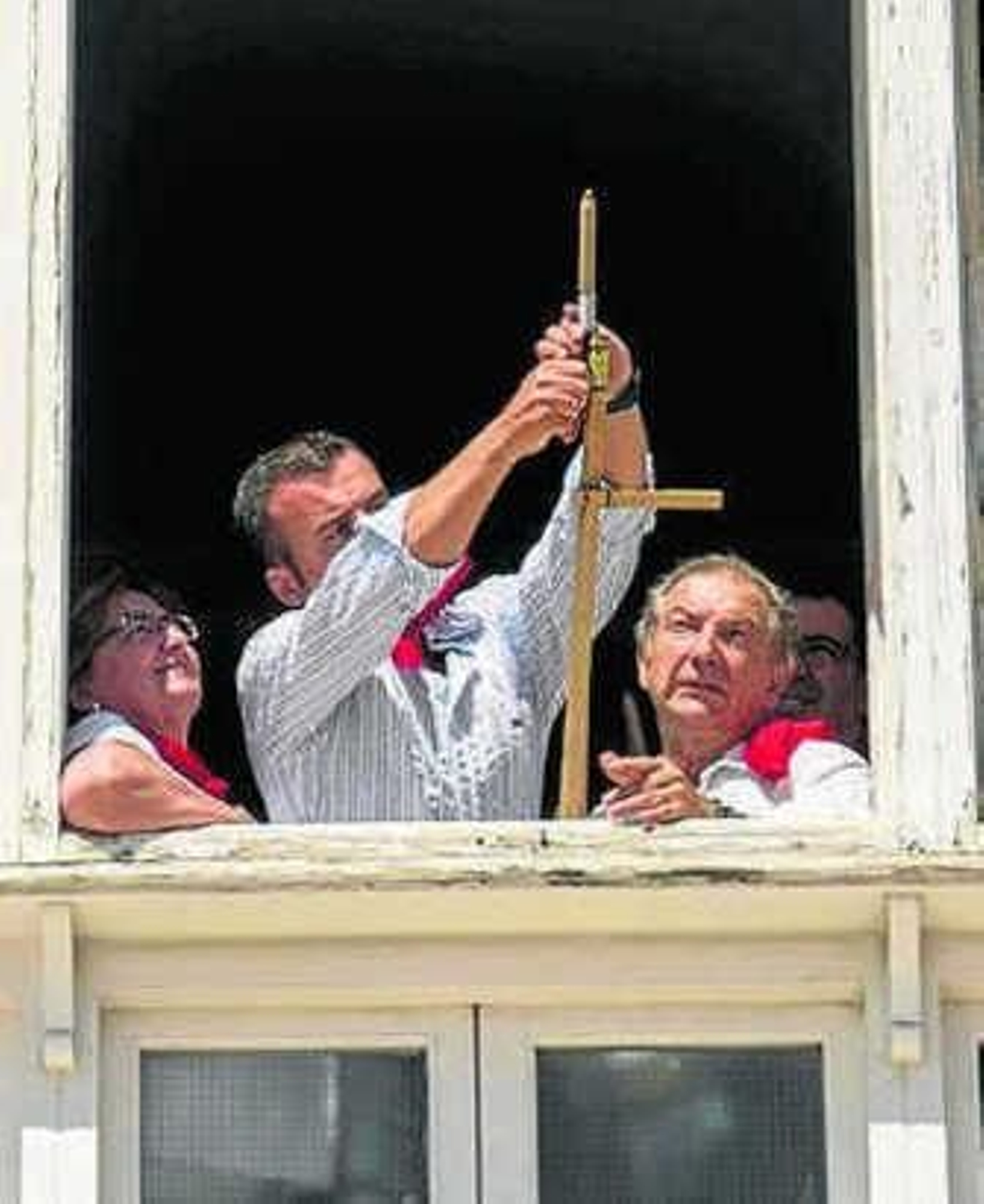 El alcalde enciende el cohete.