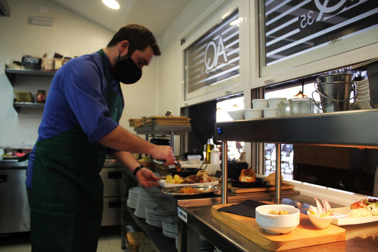 Un cocinero ultima un plato que está a punto de salir al restaurante.