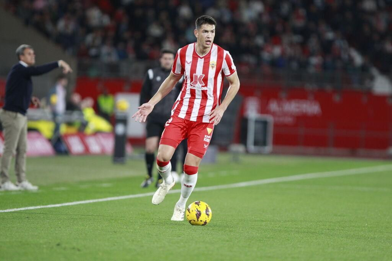 César Montes conduce con el balón en campo rival.