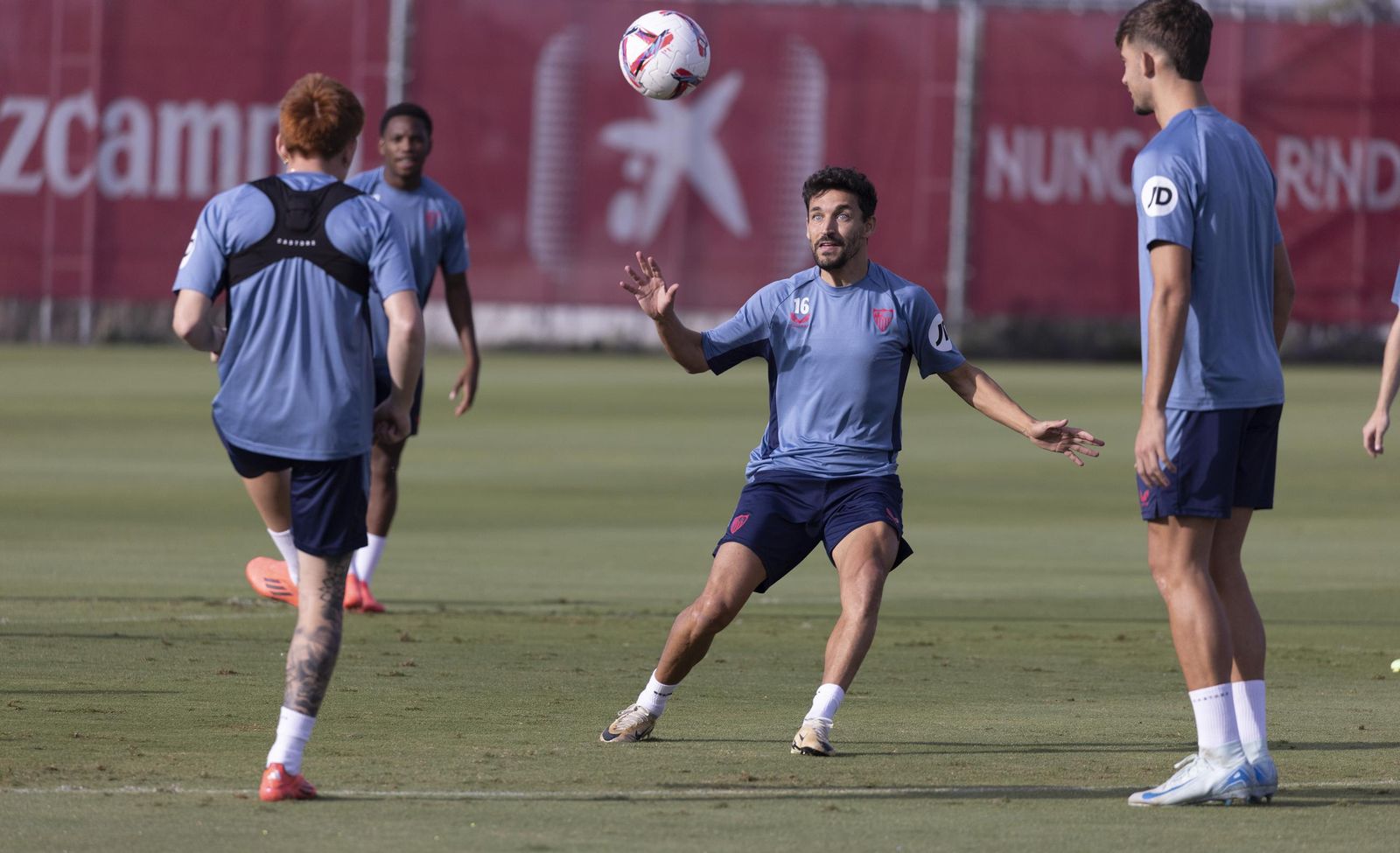 Jesús Navas espera el balón en un rondo con Valentín Barco y Kike Salas.