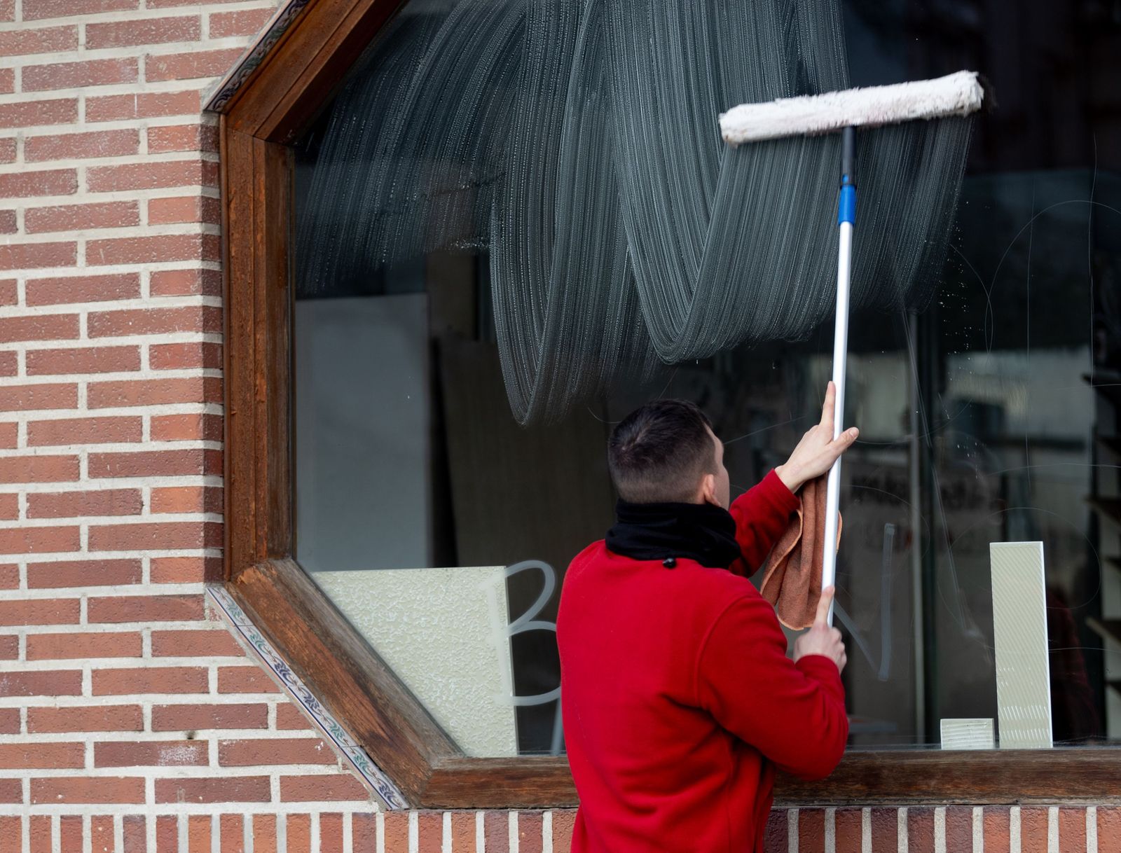 Trabajador limpiando cristales