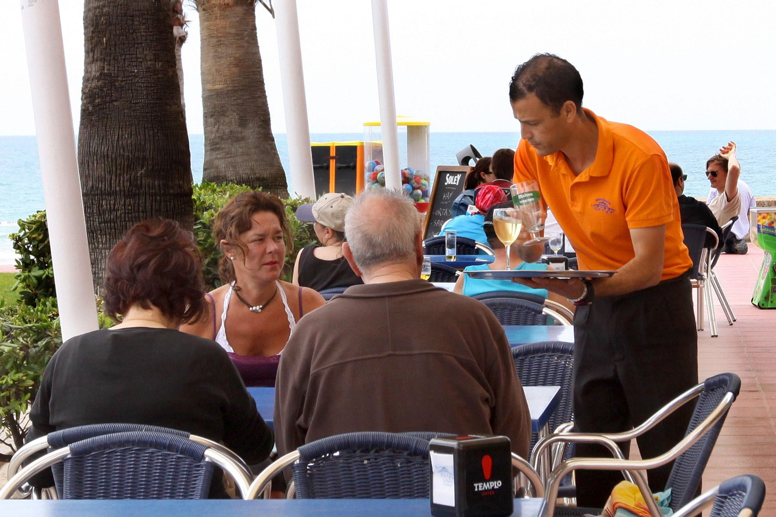 Un camarero atiende a unos clientes en Chiclana