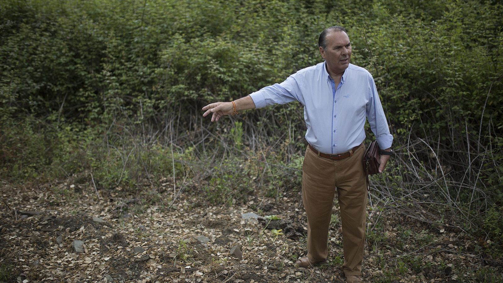 El policía señala un punto de la finca.