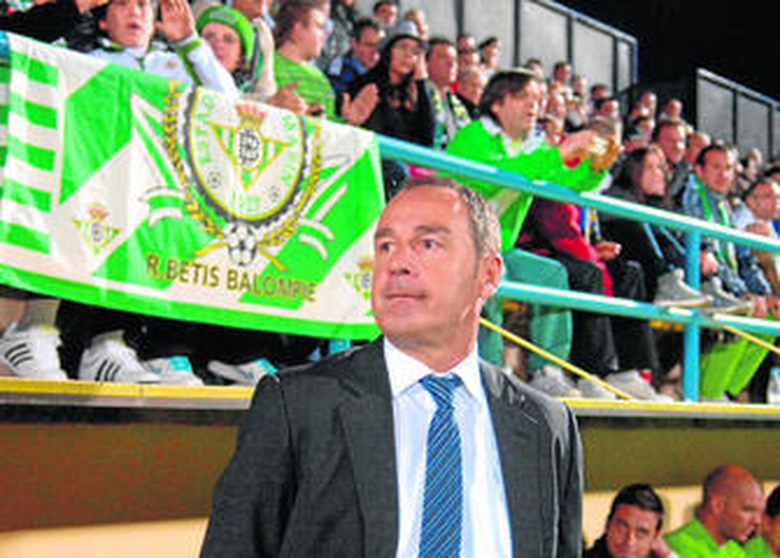 Vístor Fernández, en el banquillo antes del inico del choque junto a algunos aficionados béticos.