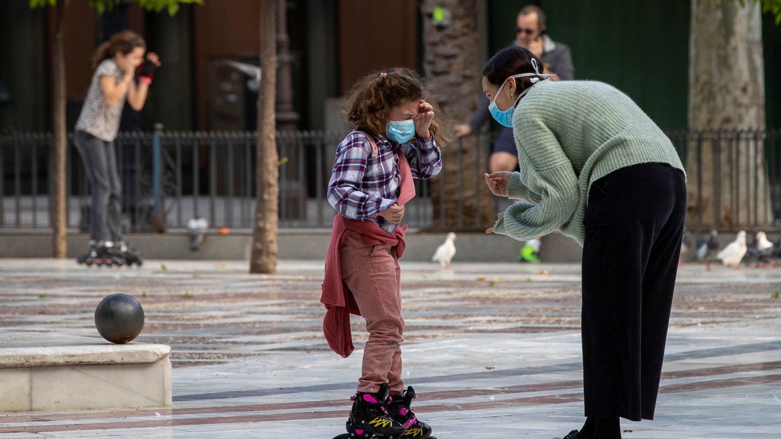 Una niña y su madre, con mascarillas.