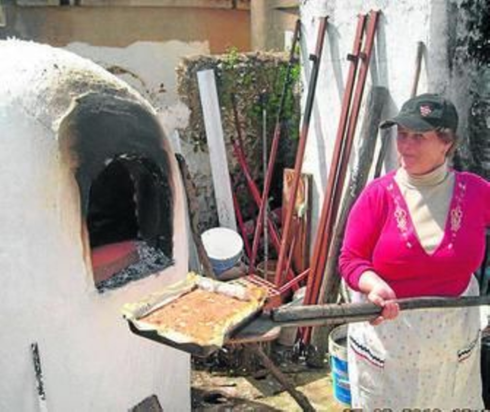 Una mujer introduce una coca en un horno en Villablanca.