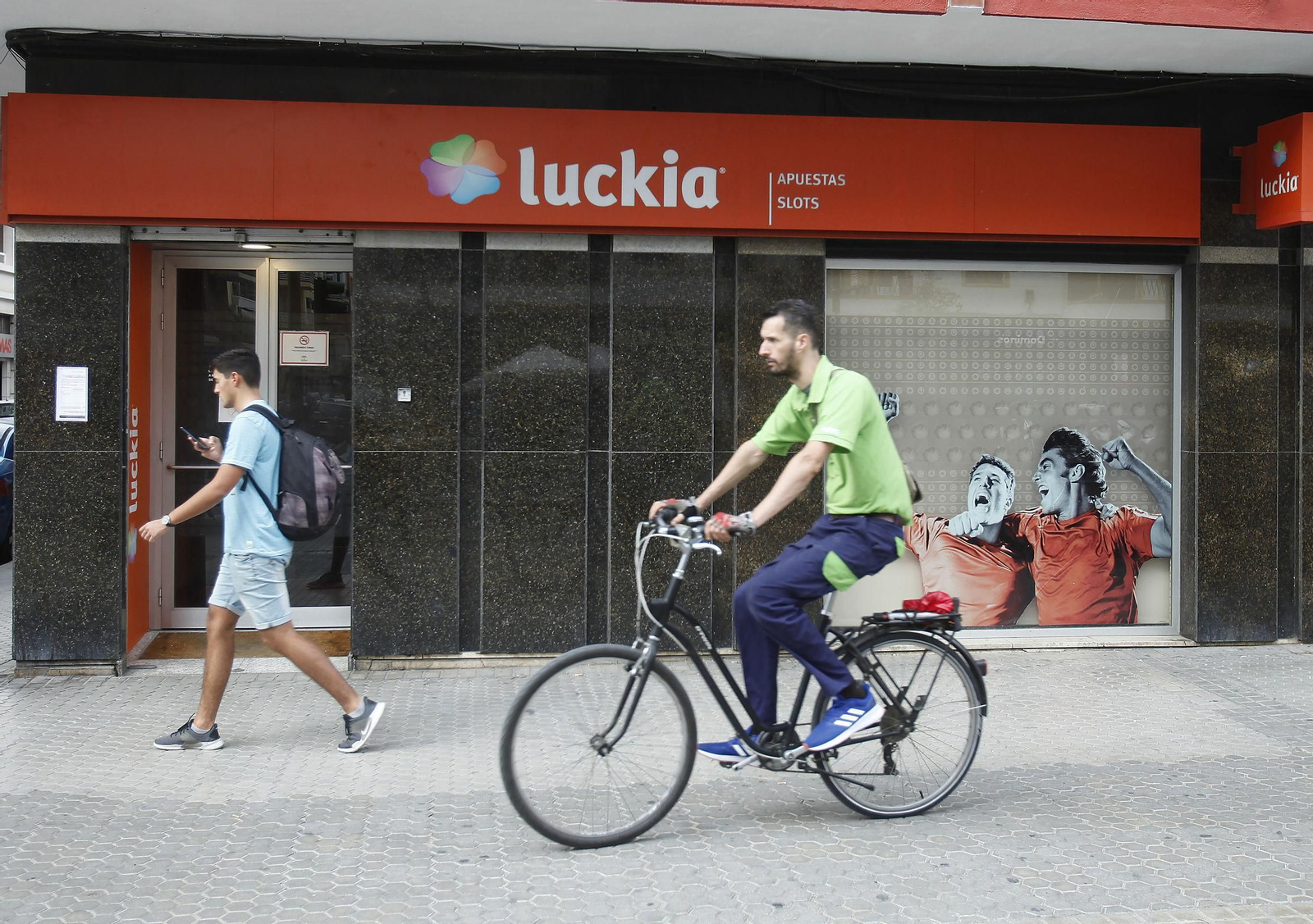Dos jóvenes pasan por delante de una casa de apuestas de la capital.