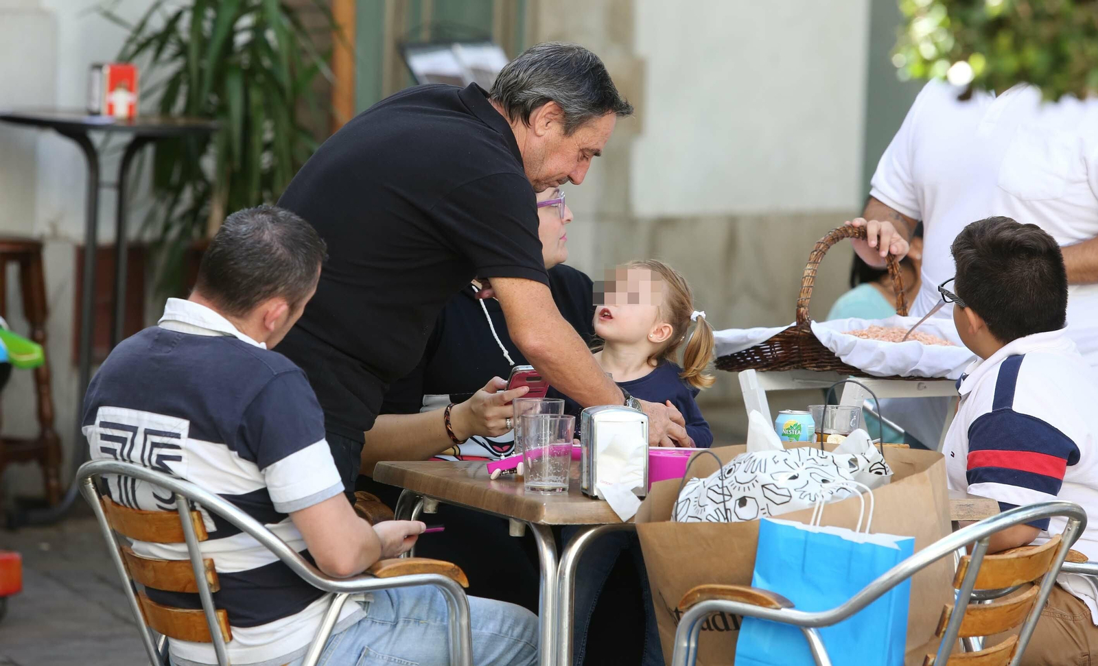 Un camarero atiende a los clientes en la terraza de un bar del centro.