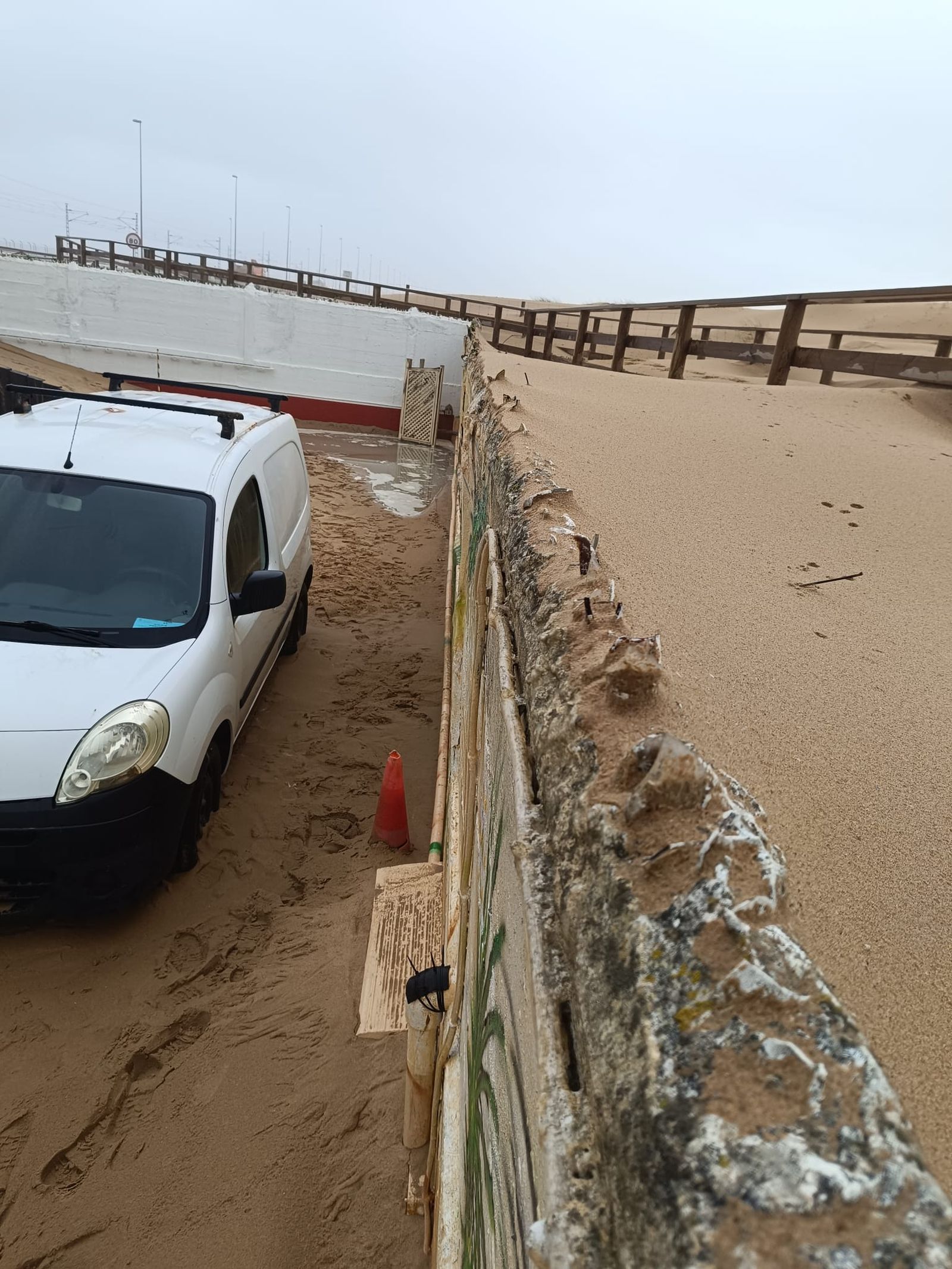 Hasta lo más alto del muro del Ventorrillo del Chato ha llegado a acumularse la arena. Al fondo, una pasarela del Eurovelo 8, competamente enterrada.