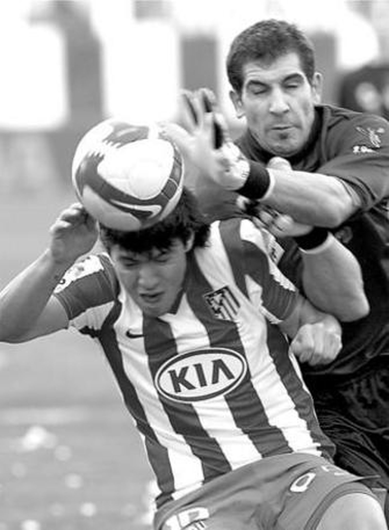 Agüero se protege ante el intento de despeje del guardameta Iraizoz.