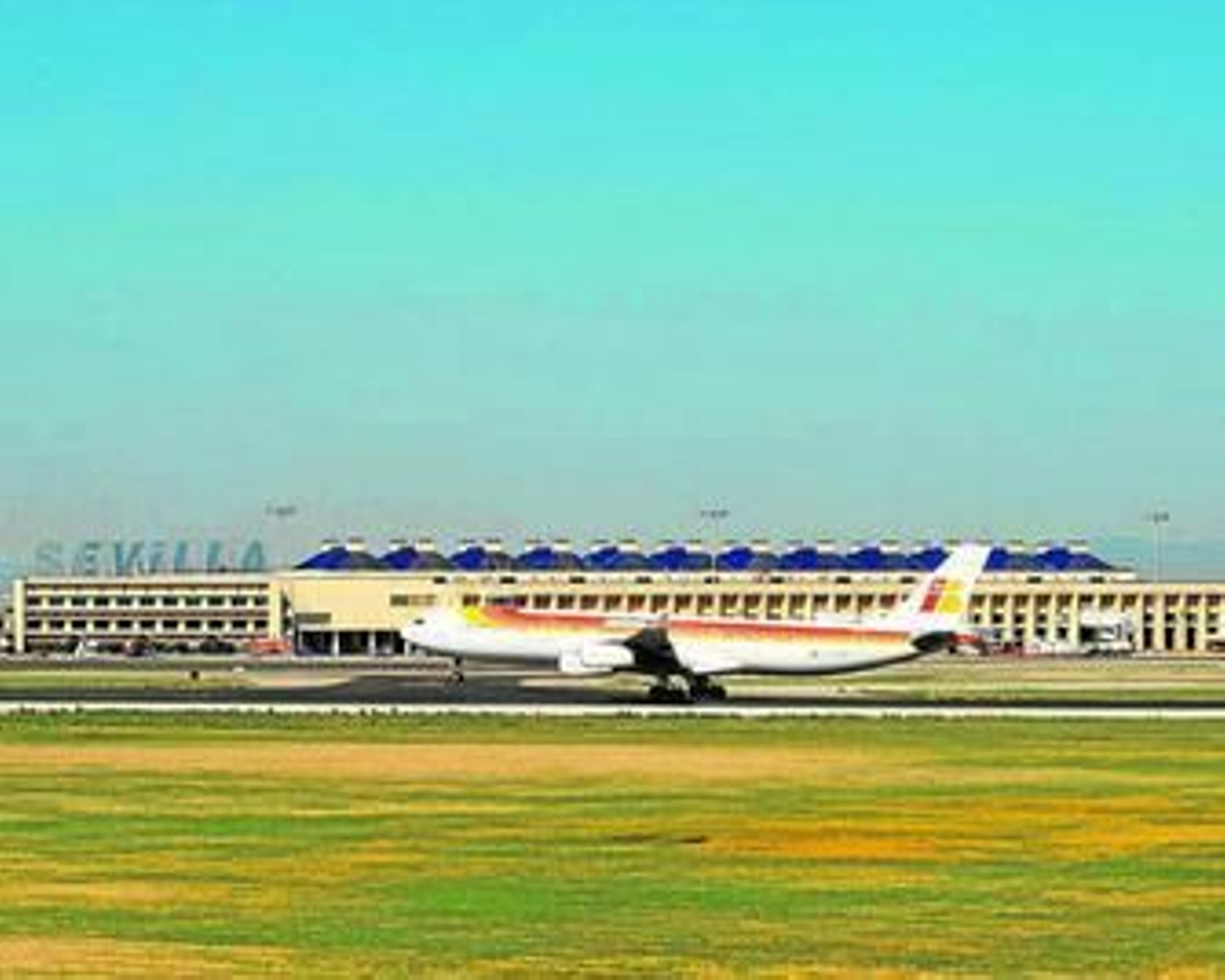 La pista de aterrizaje del aeropuerto de Sevilla con el edificio de la terminal al fondo.