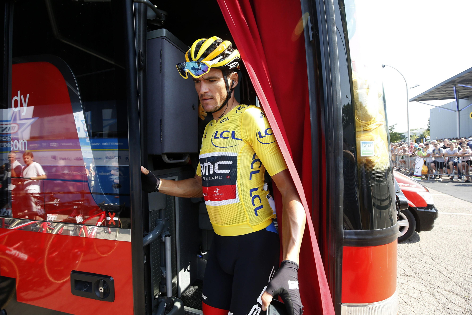 Greg van Avermaet, que llegó líder a la jornada de descanso, junto a un autobús del equipo BMC.