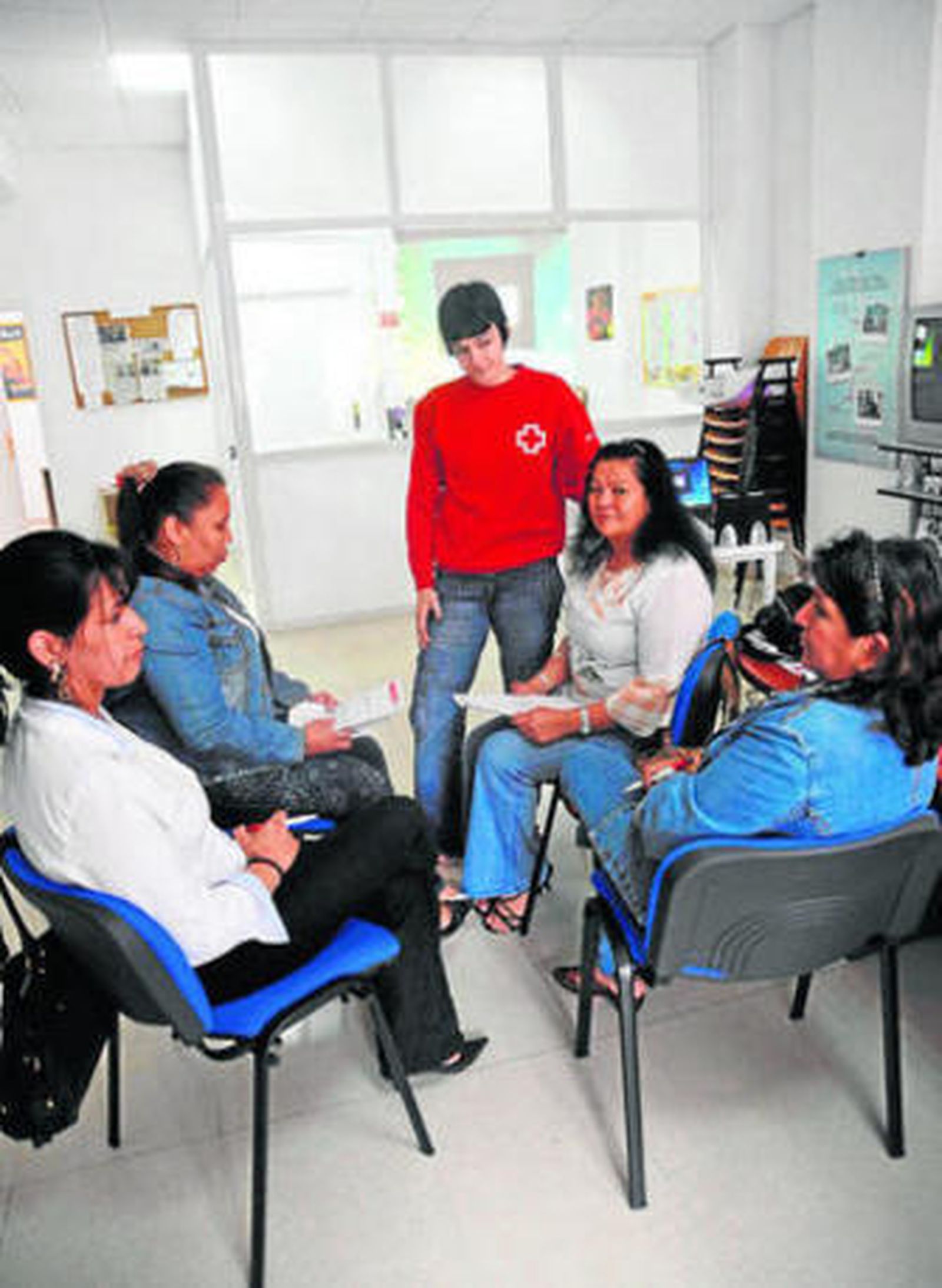 Una voluntaria de Cruz Roja conversa con un grupo de mujeres.