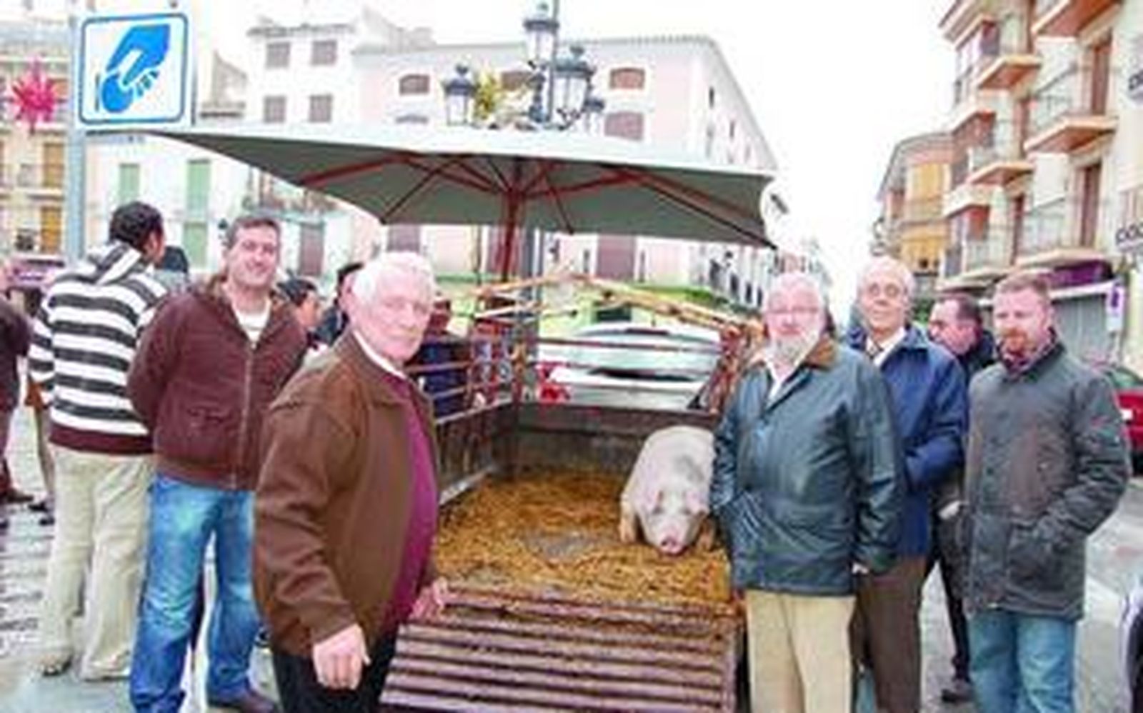 Miembros de la Hermandad de San Antón, junto al cerdo del sorteo.