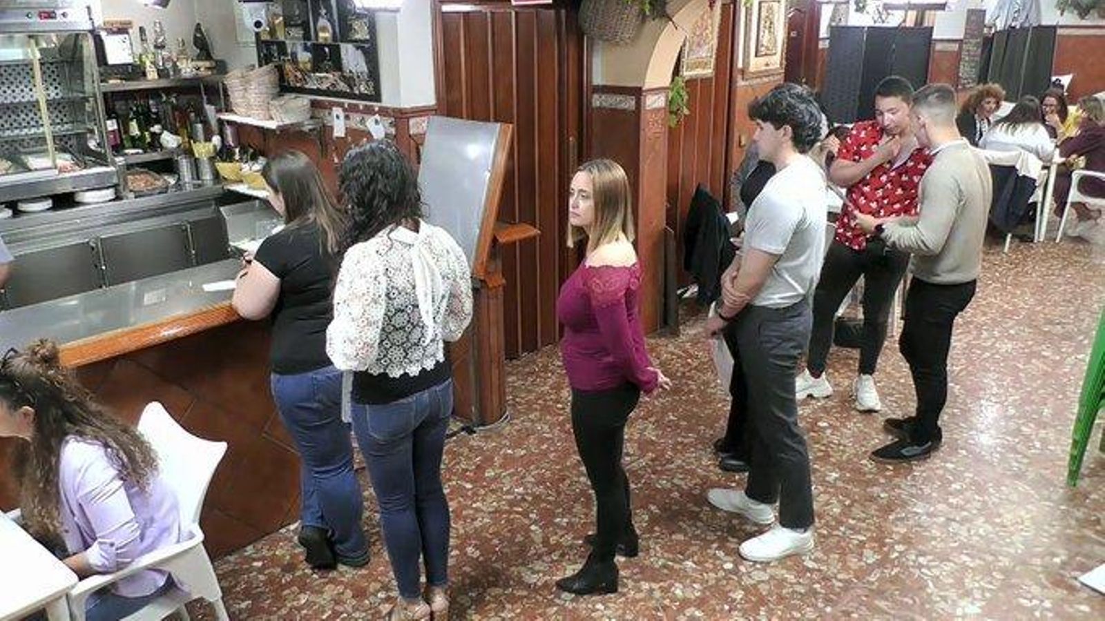 Los clientes de El Palomo aguardan para  pedir con sus comandas a mano