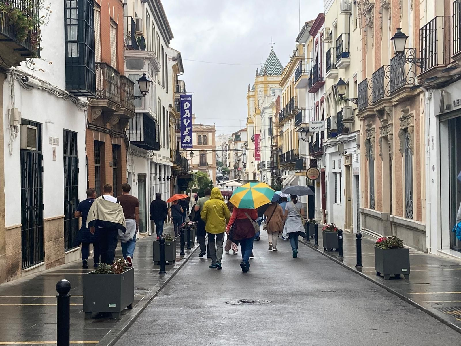 Un grupo usa paraguas y chubasqueros para protegerse de la lluvia en Ronda.