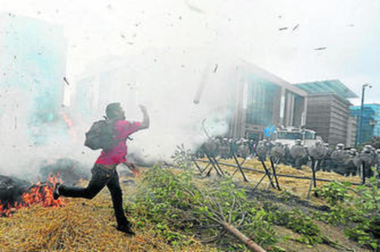 Un agricultor lanza un tronco a la policía en las manifestación de ayer en el barrio europeo de Bruselas.