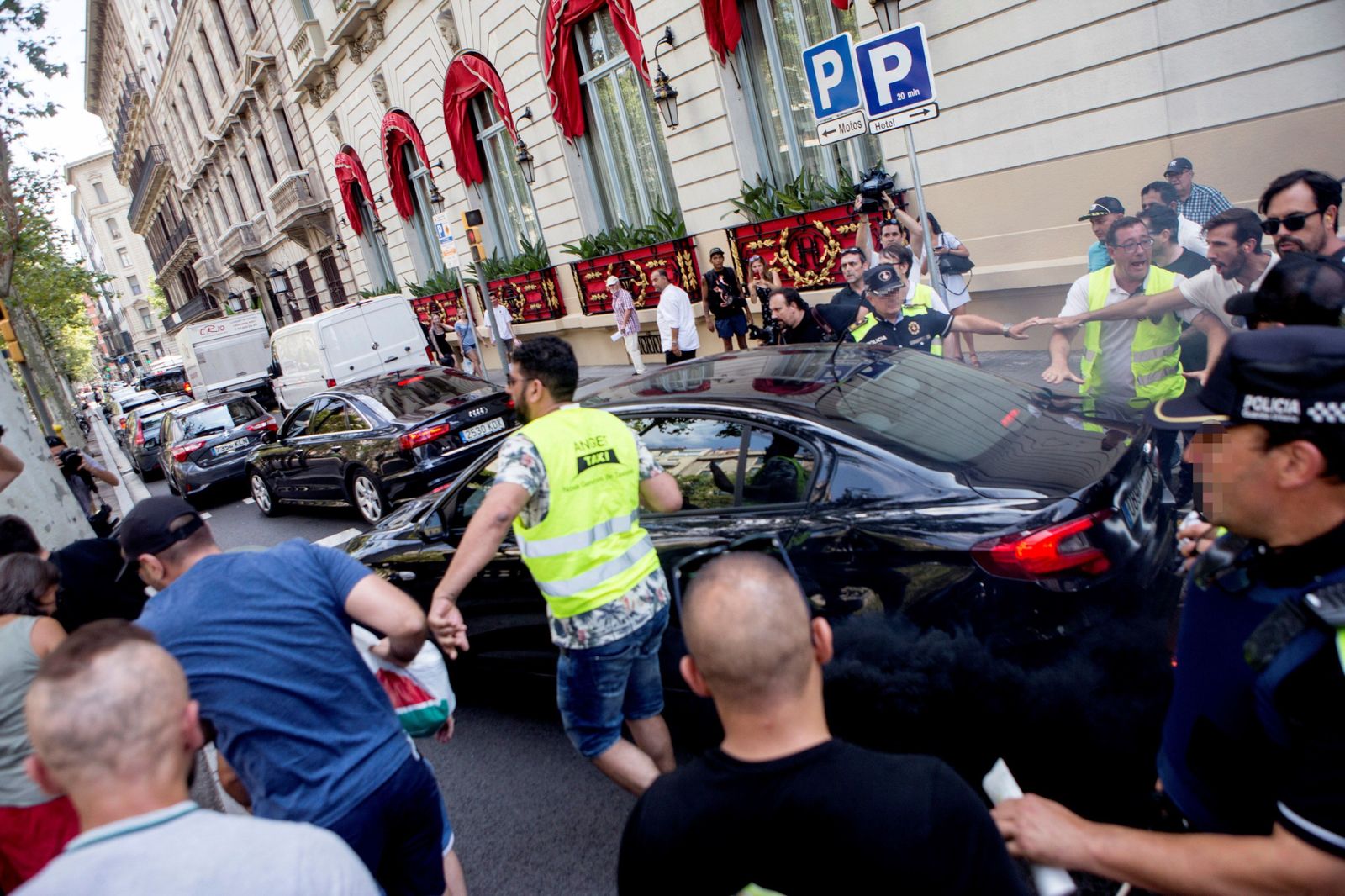 Taxistas increpan a un vehículo frente al Hotel Palace durante la manifestación.