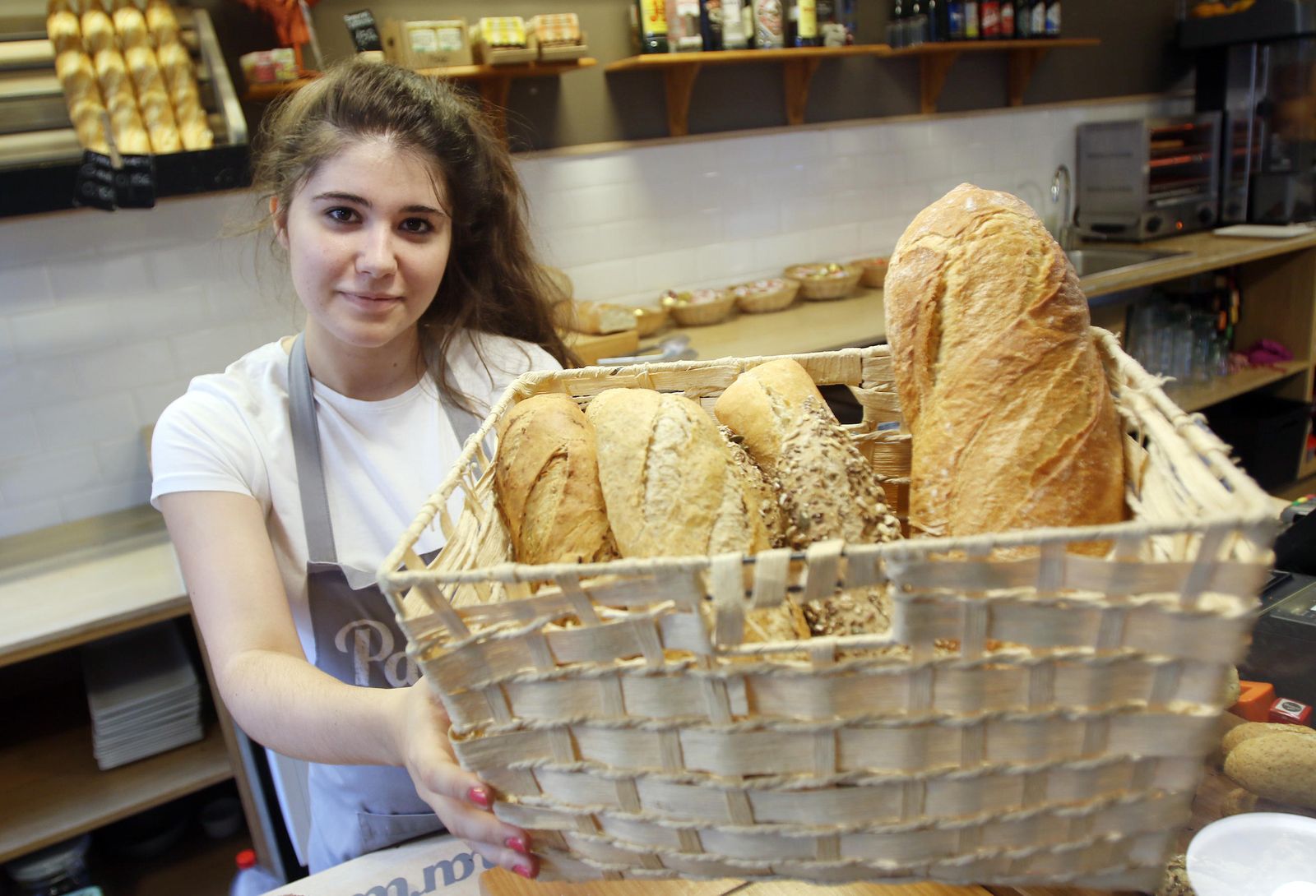 Una de las empleadas de la Cafetería Panaria muestra algunas variedades de pan que ofrece este establecimiento.